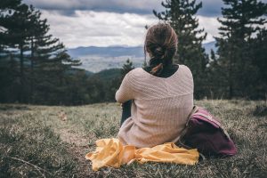 A woman sits alone while looking out at the landscape before her. Depression treatment in Greenwood Village, CO can help you address isolation. Contact a depression therapist in Greenwood Village, CO or search therapist near me for depression in Greenwood Village, CO today.