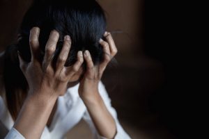 Girl holding her head feeling down. Are you feeling down and overwhelmed? Learn more about how a depression therapist in Greenwood village, CO. 